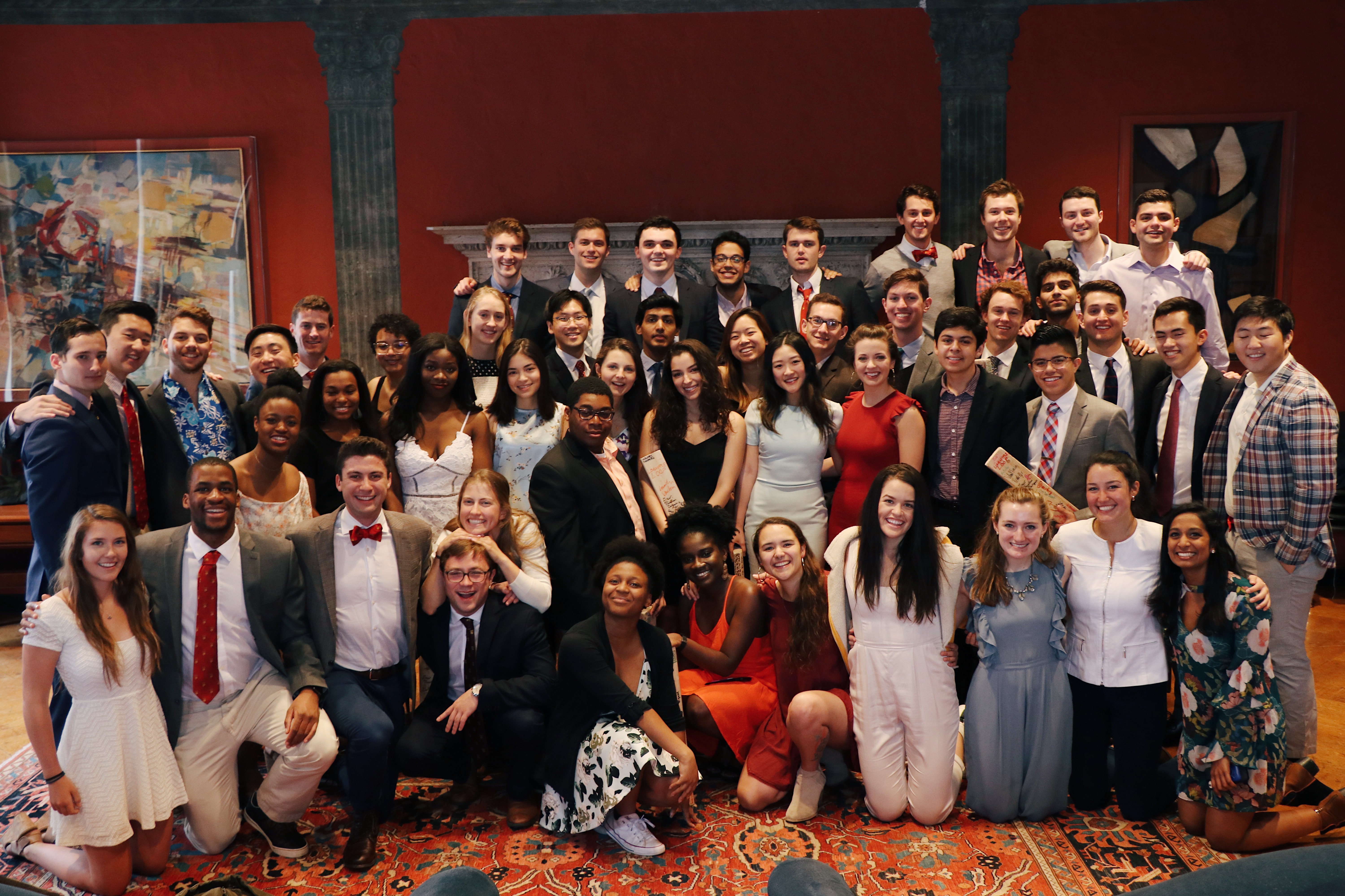 A large group of Oak friends gathered indoors for a formal event