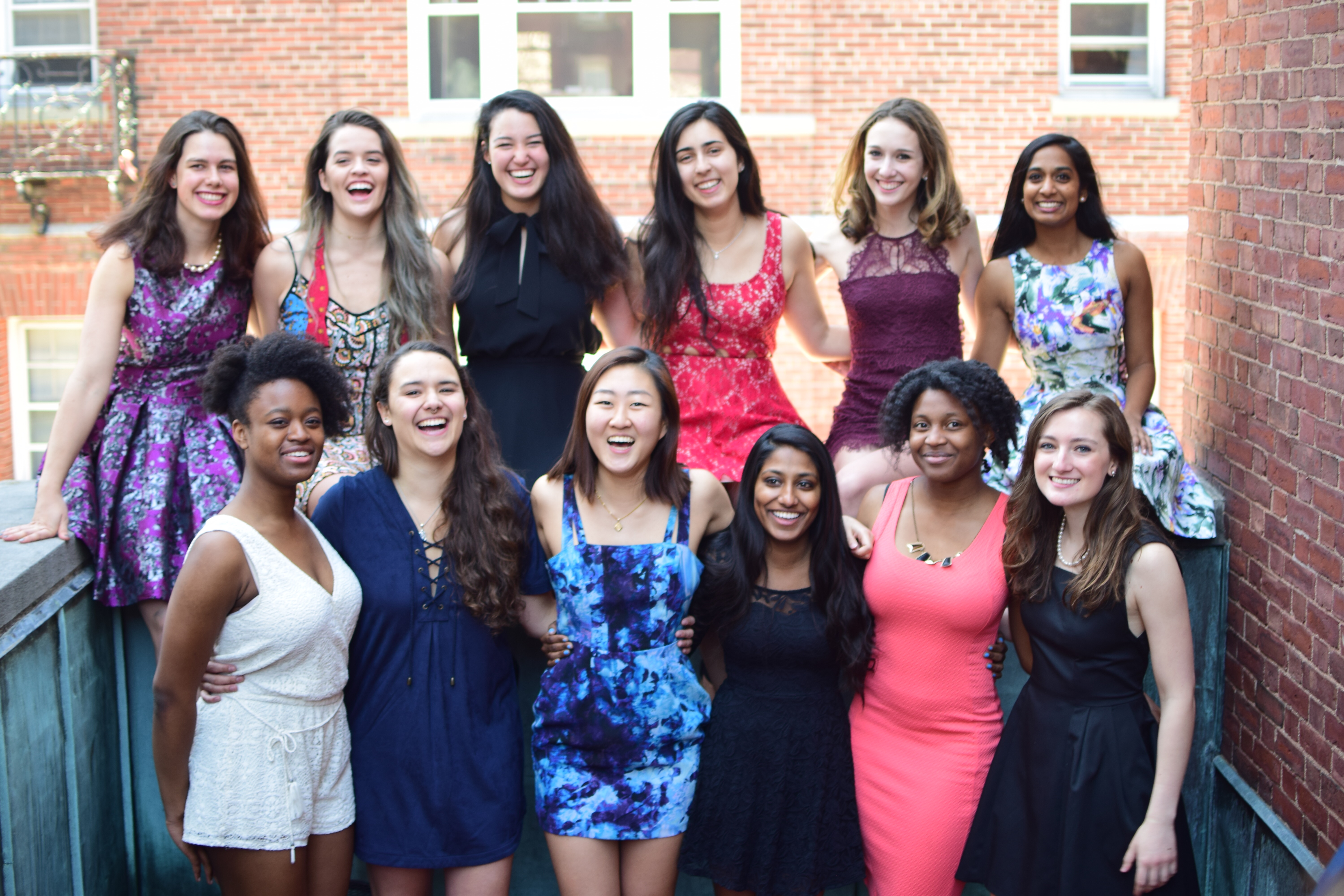 A group of friends in formal clothes gathered outside a brick building