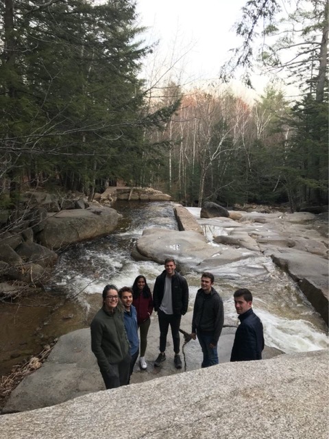 Friends standing together among rocks in a wooded landscape