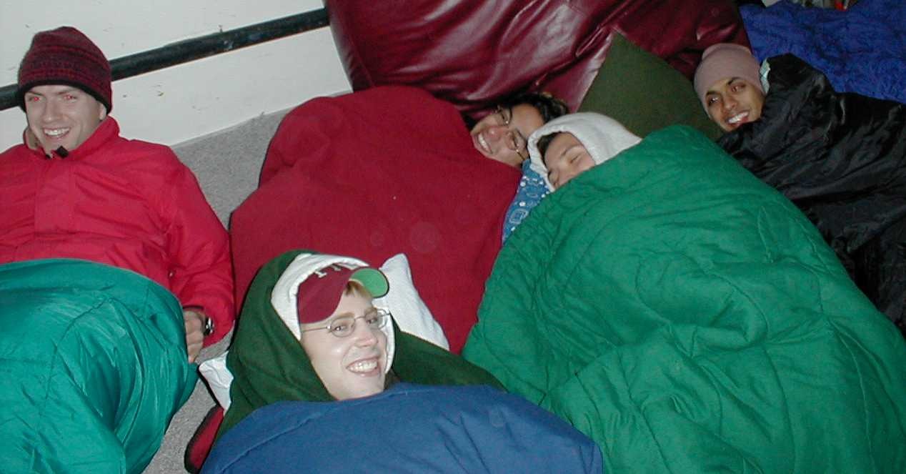 Friends bundled in colorful sleeping bags