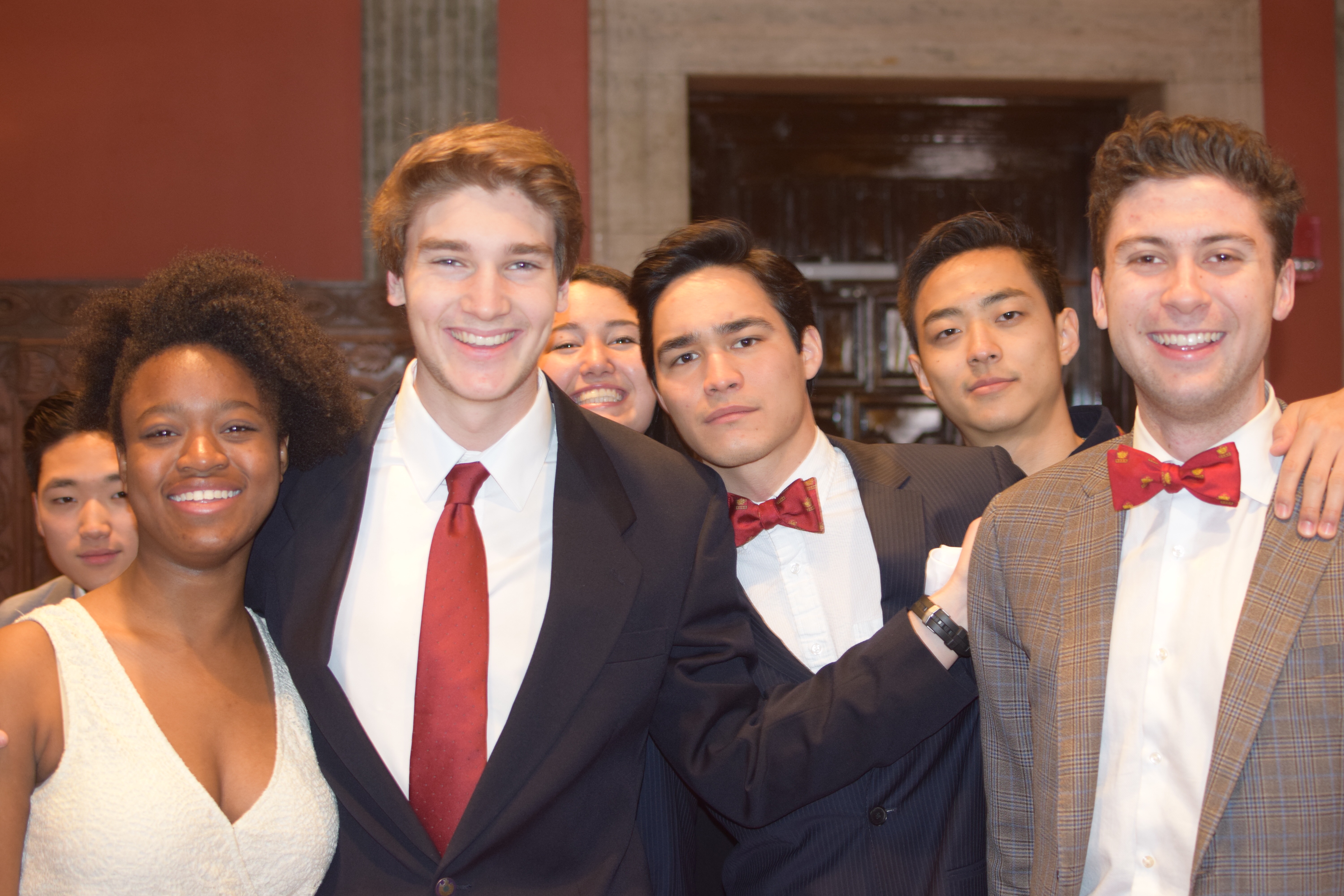 Friends in suits and formal clothes posing together indoors