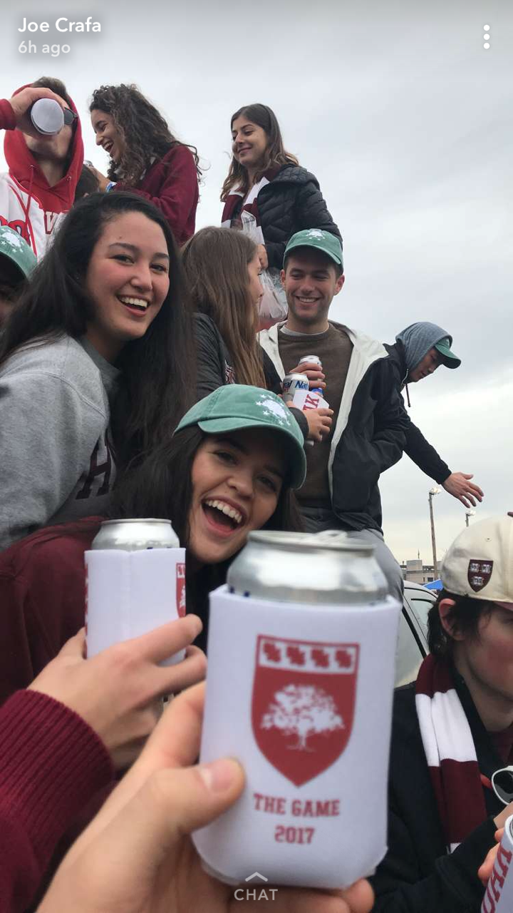 Friends in Harvard clothing taking a group photo outside